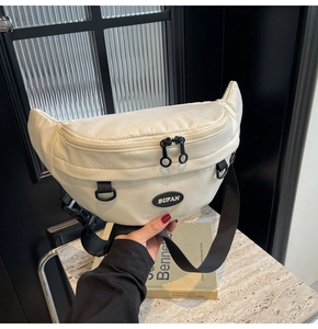 Dettaglio della borsa pettorale in tela bianco sporco con trama fine e logo BUFAN