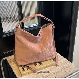 Detail of pink lavender tote bag showing crinkled leather texture and silver chain strap