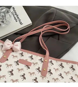 Detail of horse print tote bag with pink handles, bow accent and golden rivets