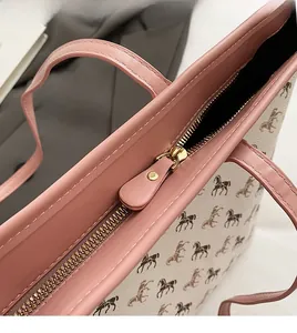 Close-up of golden metal zipper and pink leather trim on horse print tote bag