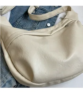Close-up of beige hobo bag showing soft pleated PU leather and metal zipper detail