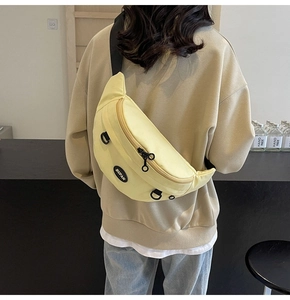 Dettaglio del borsello giallo chiaro con logo BUFAN e tracolla in nylon indossato dal modello