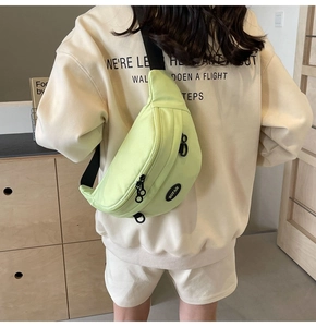 Dettaglio della borsa pettorale in tela verde chiaro con cinturino nero e logo BUFAN