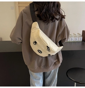 Dettaglio del marsupio in tela beige con tracolla nera regolabile e doppia cerniera