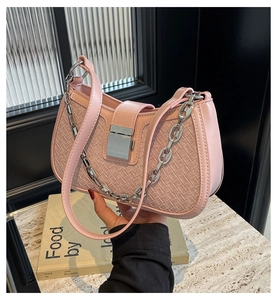 Detail of pink woven texture crossbody bag with silver chain strap and metal buckle