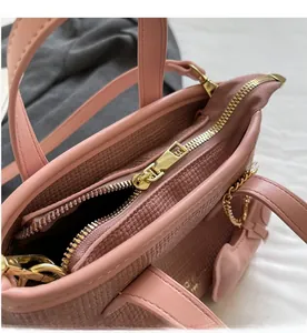 Dettaglio della borsa a secchiello rosa con cerniera dorata e finta pelle testurizzata