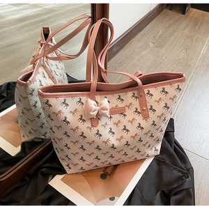 Detailed view of horse print tote bag with pink bow accent and leather handles