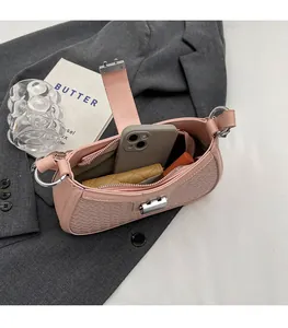 Interior view of small pink baguette bag showing storage for phone and lipstick