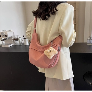 Detail of pink crescent shoulder bag with plush star charm and matte fabric texture