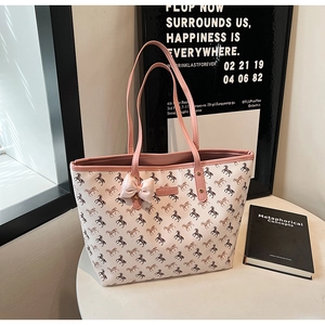 Detail of cream tote bag with horse print, pink shoulder strap and decorative silk bow