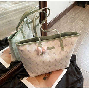 Detail of horse print tote bag with green leather trim and pink satin bow accessory