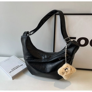 Detail of black crescent hobo bag featuring premium texture and cute star charm