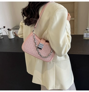 Pink woven underarm bag featuring a chunky silver chain and metallic buckle detail