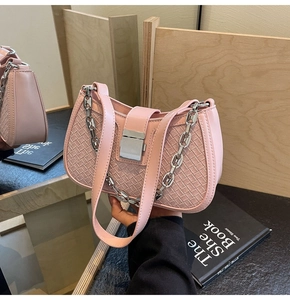 Detail of pink woven texture shoulder bag featuring chunky silver chain and metal clasp