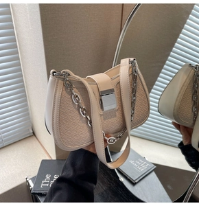 Detail of cream woven leather underarm bag with silver square buckle and chain strap