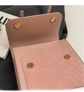 Détail d'un sac à dos rose avec fermoir magnétique doré et textures de cuir rayées