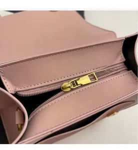 Gros plan d'un sac à dos rose en cuir avec fermeture éclair dorée et doublure noire