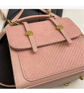 Gros plan d'un sac à dos rose en tissu et cuir avec une boucle en métal doré
