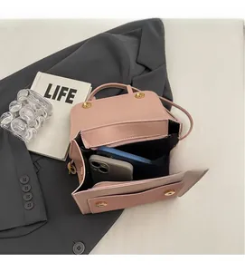 Détail du sac en cuir rose montrant l'espace pour téléphone et parapluie