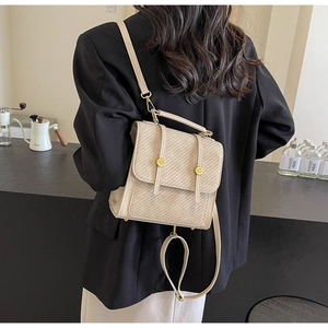 Détail d'un sac à dos structuré beige avec texture sergé et boucle en métal doré