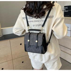 Détail d'un petit sac à dos rétro montrant la texture cuir PU et le rabat en tissu gris