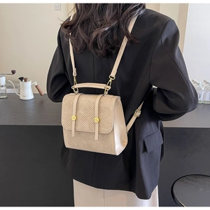 Détail du sac à dos en cuir crème avec rabat texturé et finitions métalliques dorées