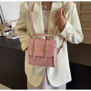 Détail d'un sac à main rose texturé avec boucles dorées dans un cadre de vie