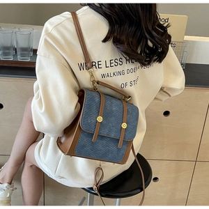 Détail d'un mini sac à dos vintage en denim et cuir avec boucles dorées sur un mannequin