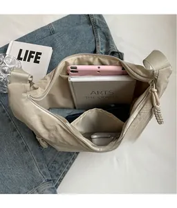 Spacious beige nylon dumpling bag interior showing tablet, books and sun umbrella storage