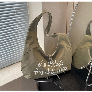 Detail of olive green canvas hobo bag with white floral print and ribbon tie closure