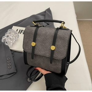 Détail de la texture sergée grise et bordure en cuir noir sur un sac à dos vintage