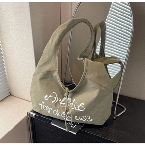 Detail of olive green canvas tote bag featuring white text and drawstring accent