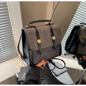 Détail d'un mini sac à dos vintage en tissu rayé, cuir noir et finitions dorées chic