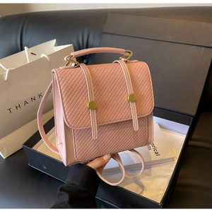 Détails d'un sac à dos rose en similicuir avec rabat gaufré et boucles dorées élégantes