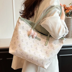 Large tote bag with horse pattern and green trim shown from a side view on a shoulder