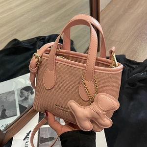 Secchiello rosa in pelle intrecciata con ciondolo a forma di cane e dettagli dorati