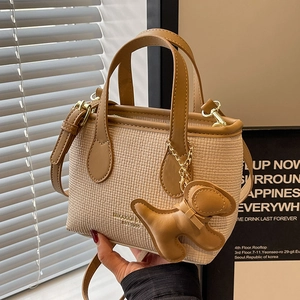 Borsa a secchiello in tessuto beige con finiture in pelle kaki e ciondolo a forma di cane