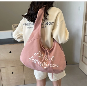 Detail of pink canvas tote bag with white lettering and spacious interior for daily use