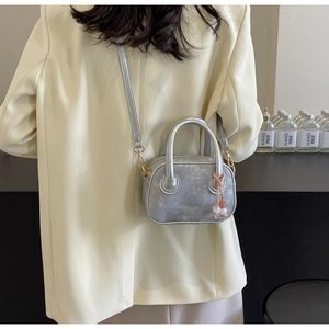 Détail du sac bowling gris argenté avec breloque en perles et finitions dorées