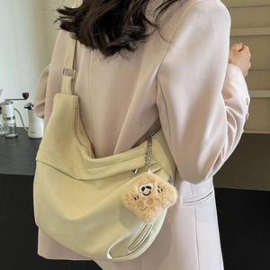 Minimalist beige hobo shoulder bag with large capacity and a yellow plush smiley pendant