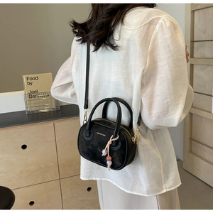 Détail du mini sac bandoulière noir avec lettrage doré et breloque en perles