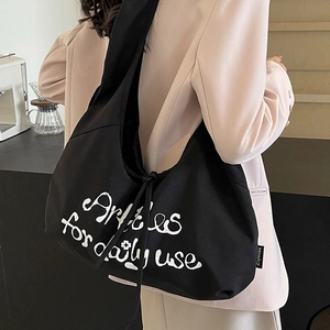 Large capacity black canvas dumpling bag with Articles for daily use print and strap