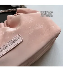 Detail of pink pleated leather texture and branded logo label on trendy cloud bucket bag