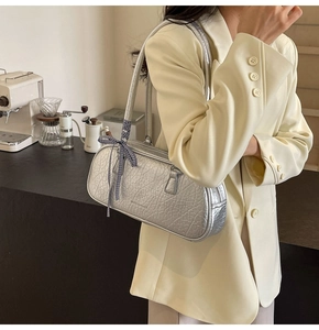 Detailed view of silver textured shoulder bag with a stylish black and white plaid scarf