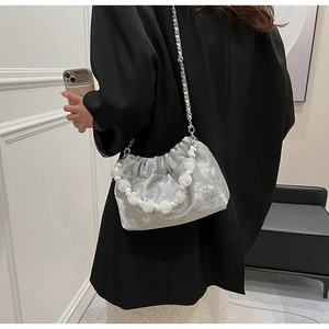 Silver pleated cloud bag with large pearl handle and metal chain on a model