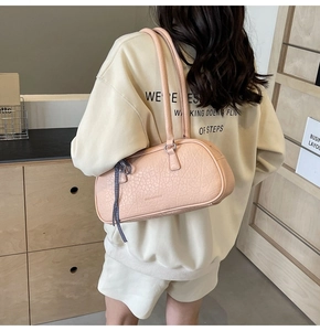 Pink pleated PU leather shoulder bag with checkered ribbon detail on a model