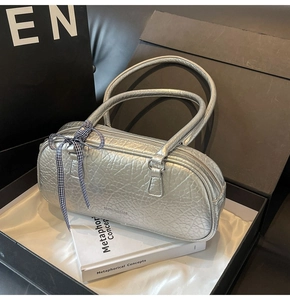 Close-up of a silver bowling bag with pleated texture and black-white checkered bow
