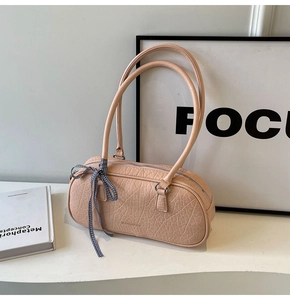 Detail of nude pink faux crocodile leather underarm bag with decorative checkered silk bow