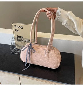 Close-up of pink stone-embossed tote bag with check ribbon and silver zipper detail