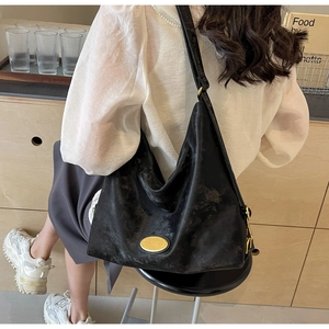 Détail du sac hobo noir texture vintage avec ferrures dorées et large bandoulière